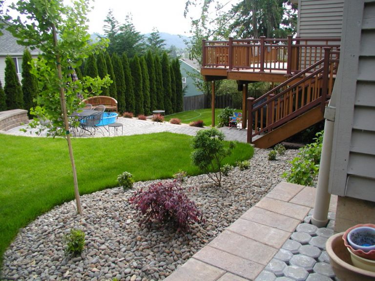 Enchanting-Green-Grass-And-White-Pebble-Areas-In-Wonderful-Backyard-Landscape-Design-Near-Wooden-Deck-768x576